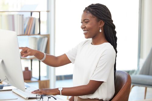 Businesswoman Pointing to Her Computer and Smiling